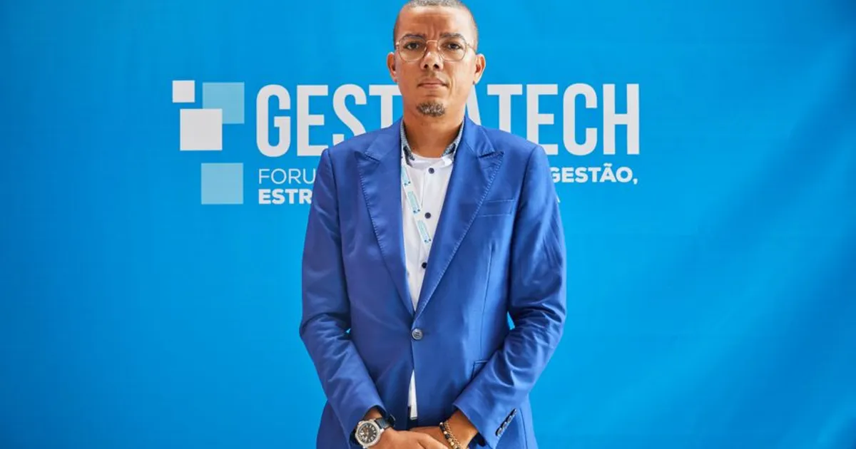 Confident businessman in blue suit at a professional conference event.