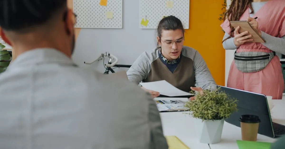Young professionals engaged in a discussion at a modern workspace table.