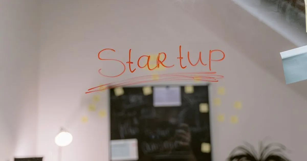 Close-up of 'Startup' written on a glass panel in an office setting.