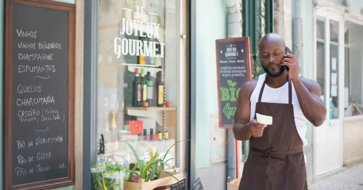 A grocery store vendor making a phone call at a gourmet shop in Lisbon, Portugal.