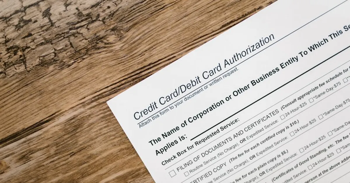 A credit card authorization form placed on a wooden desk, highlighting business paperwork essentials.