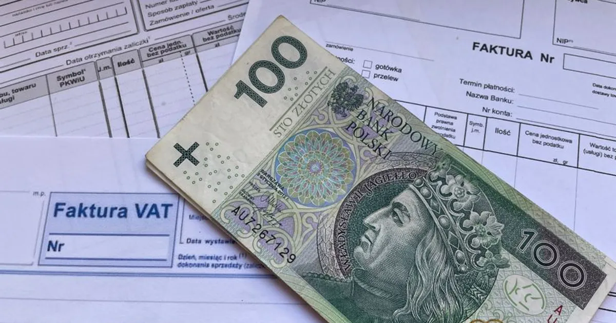 A 100 Polish Zloty note placed on top of business VAT invoices, symbolizing finance and economics.